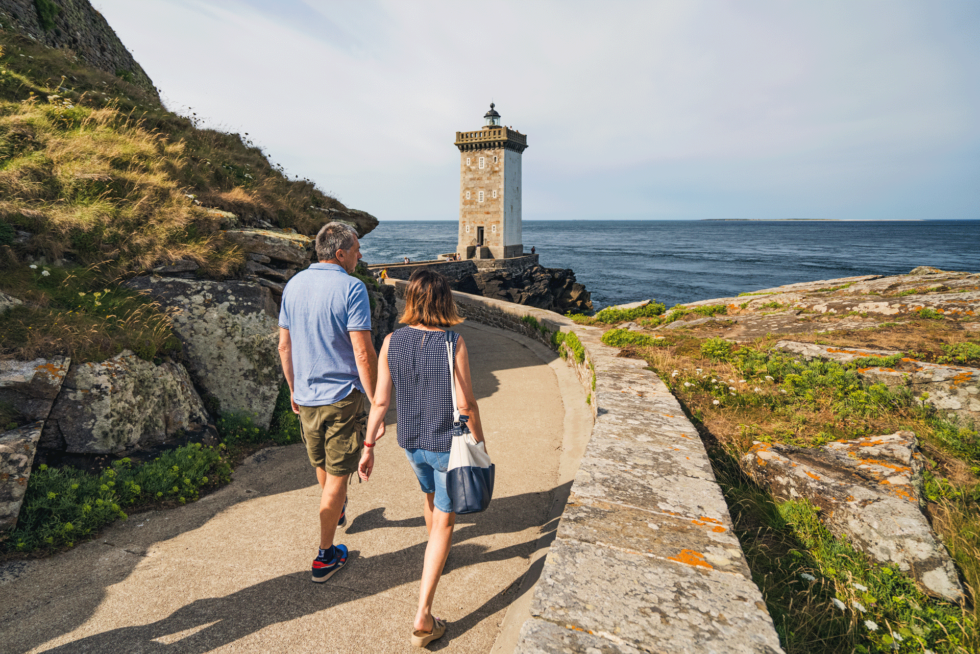 Un couple se dirige vers le phare de Kermorvan.